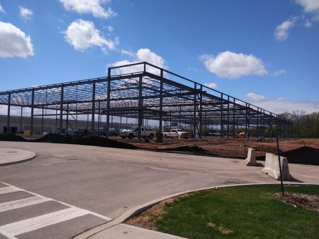 White vehicles parked under the steel frames