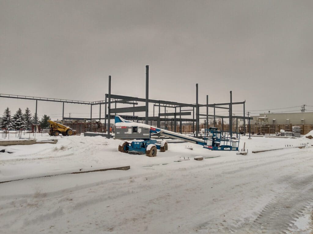 Snow covering the construction site and its vehicles