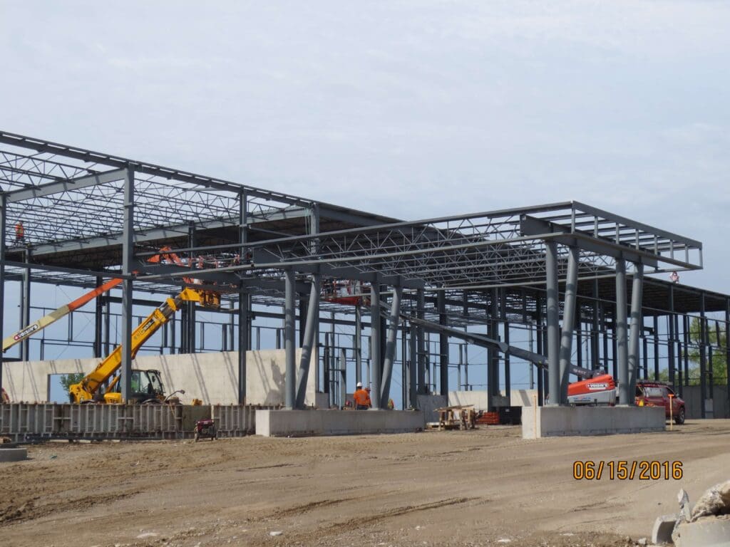 Construction personnel and vehicles building steel frames